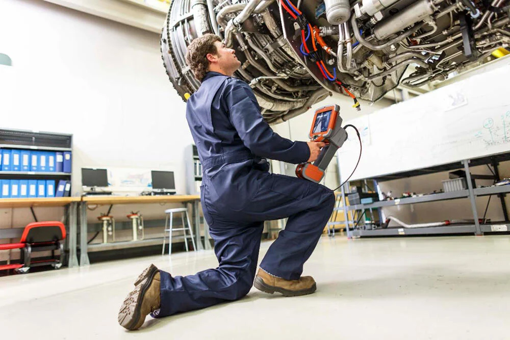 Technician performing Borescope inspection on an engine
